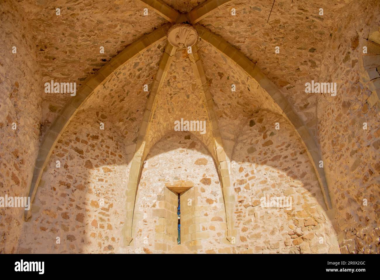 Aus der Nähe antike Kirche und ein kleines Fenster in den Festungen einer Burg in der Altstadt von Tossa de Mar, Costa Brava, Katalonien, Spanien. Stockfoto