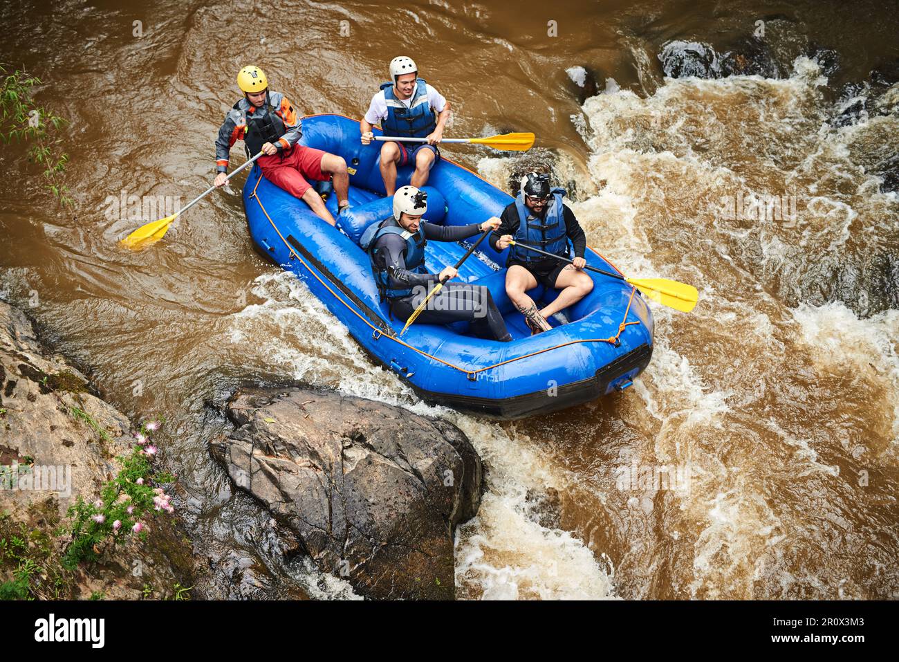 Durch die Stromschnellen. Aufnahme einer Gruppe junger Freunde beim Wildwasser-Rafting Stockfoto