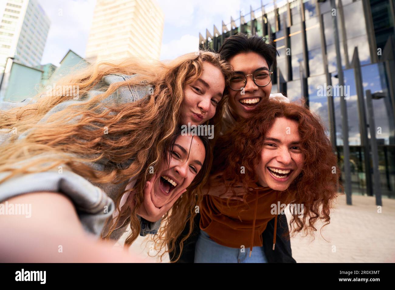 Eine Gruppe von Schülerfreunden, die sich im Freien amüsieren und ein Selfie machen, während sie beim Huckepack in die Kamera schauen Stockfoto