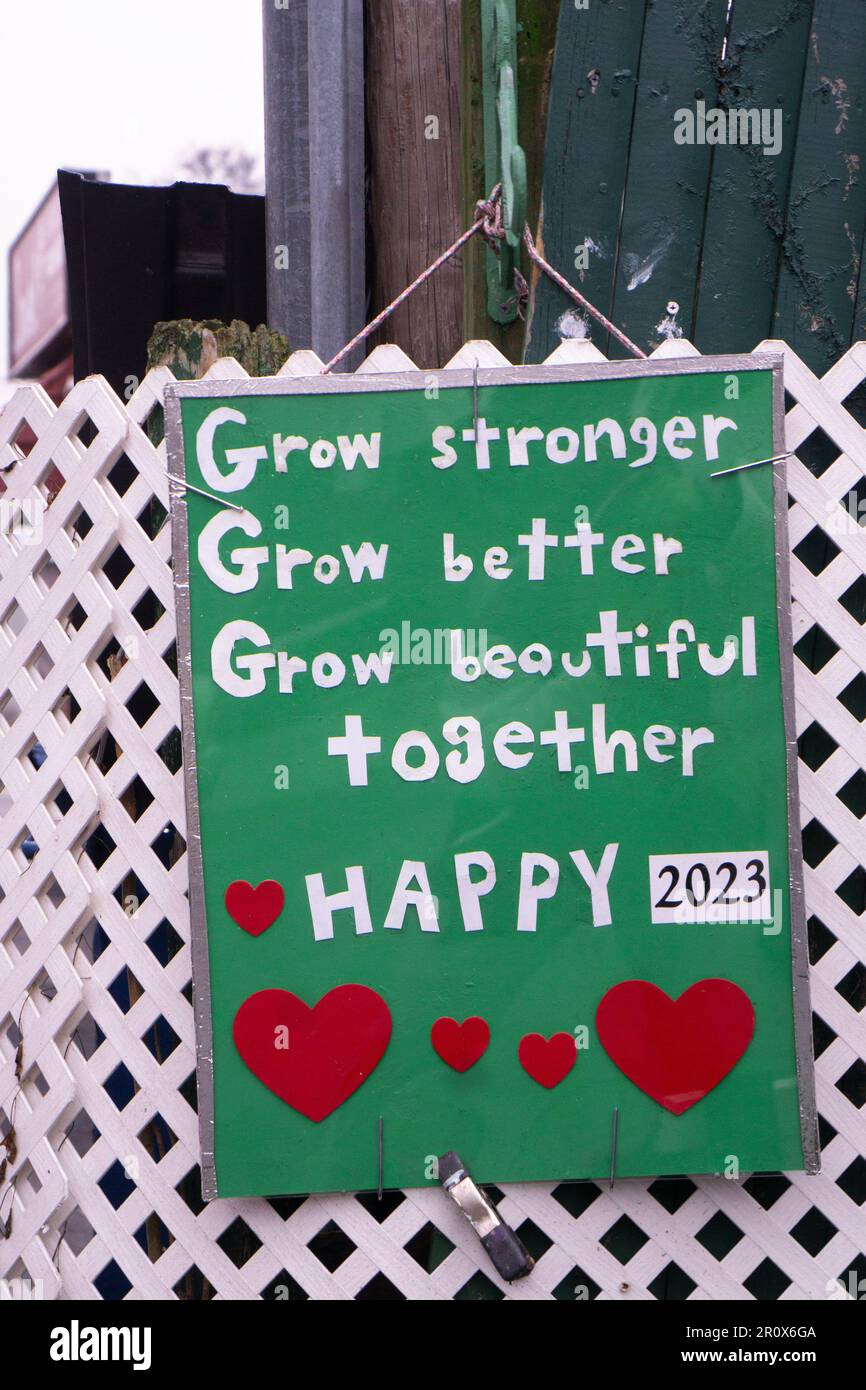 ALLES GUTE ZUM 2023. Eine hausgemachte Silvester-Karte mit den Wünschen nach Selbstverbesserung und Einheit. Auf einem Zaun vor einem Haus in Flushing, Queens, New York. Stockfoto