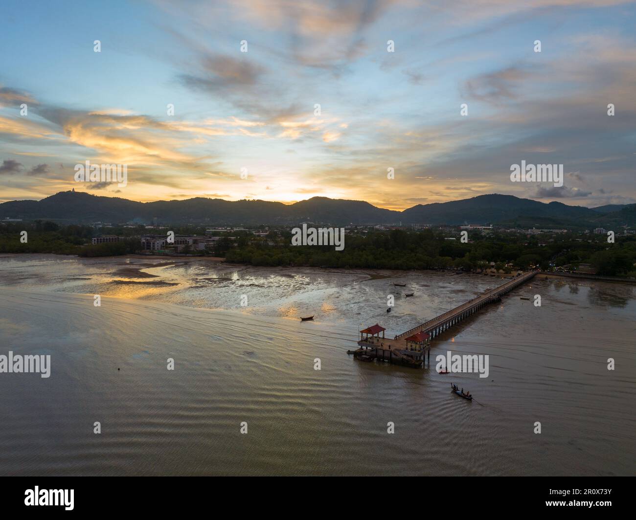 Luftaufnahmen über dem Palai Pier bei wunderschönem Sonnenuntergang. Der Palai Pier liegt neben dem Chalong Pier. Fischerboote parken am Strand. Farbenfrohe Wolke Stockfoto