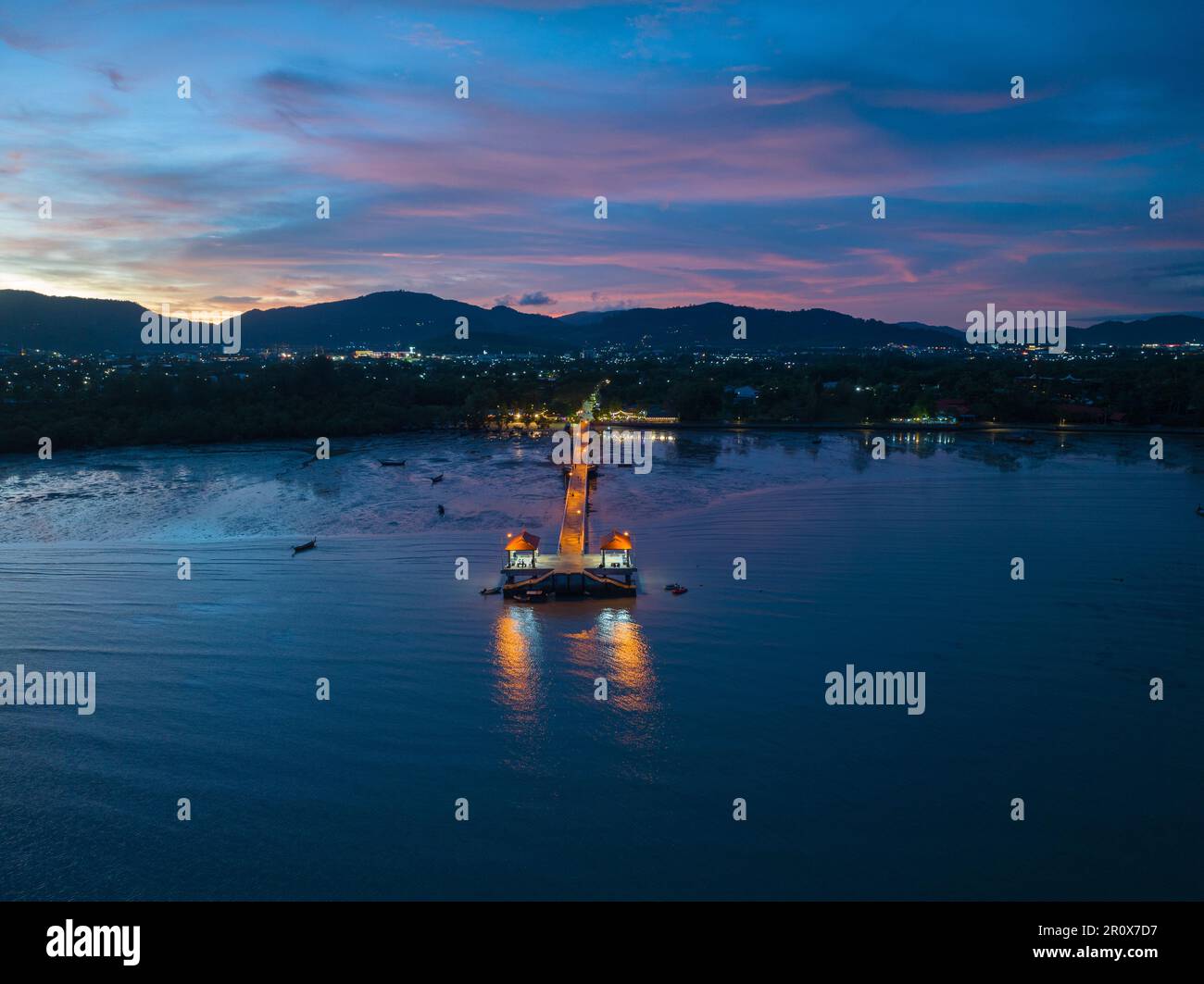 Luftaufnahmen über dem Palai Pier bei wunderschönem Sonnenuntergang. Der Palai Pier liegt neben dem Chalong Pier. Fischerboote parken am Strand. Farbenfrohe Wolke Stockfoto