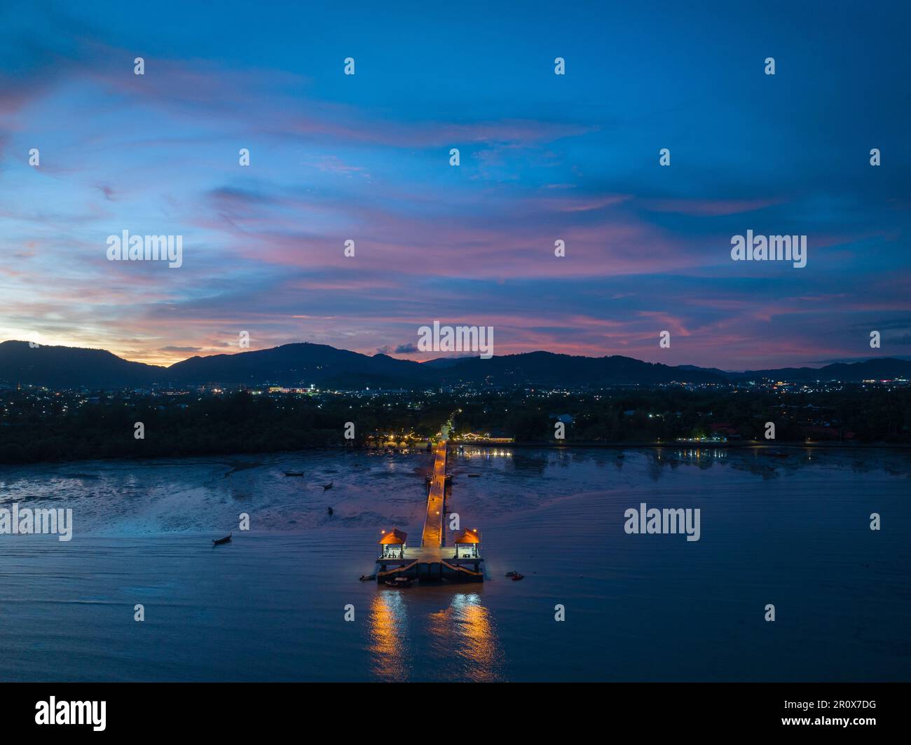 Luftaufnahmen über dem Palai Pier bei wunderschönem Sonnenuntergang. Der Palai Pier liegt neben dem Chalong Pier. Fischerboote parken am Strand. Farbenfrohe Wolke Stockfoto