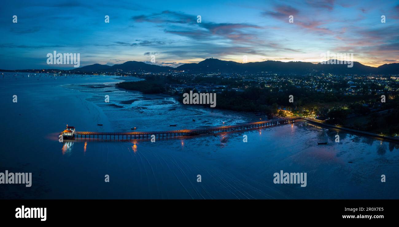 Luftaufnahmen über dem Palai Pier bei wunderschönem Sonnenuntergang. Der Palai Pier liegt neben dem Chalong Pier. Fischerboote parken am Strand. Farbenfrohe Wolke Stockfoto