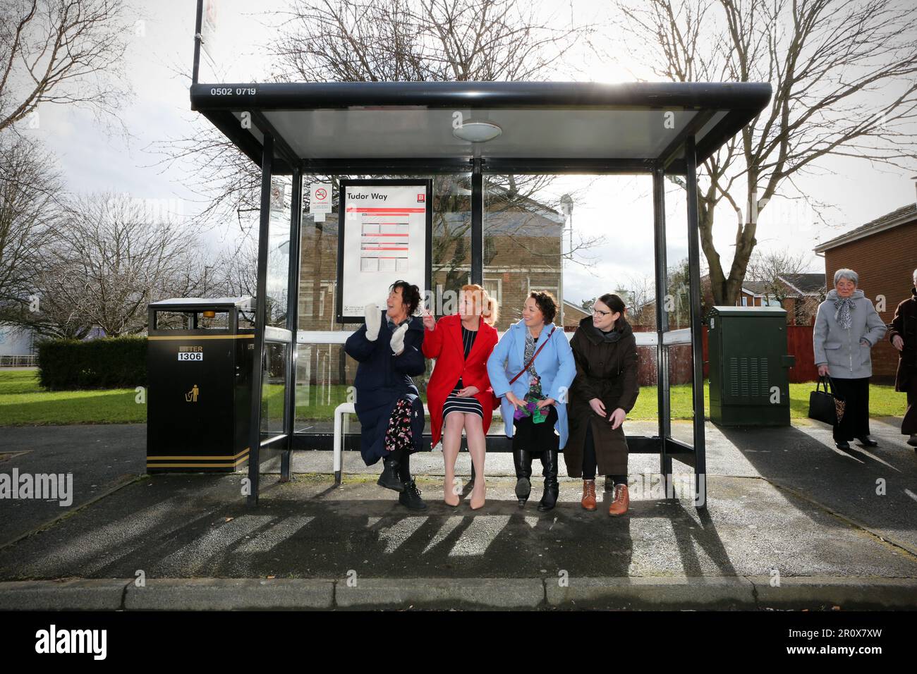 Die Labour-Abgeordnete und die Staatssekretärin für Verkehr Louise Haigh (roter Mantel) warten an einer Bushaltestelle mit einheimischen Einwohnern, die an einem Bruch gelitten haben Stockfoto