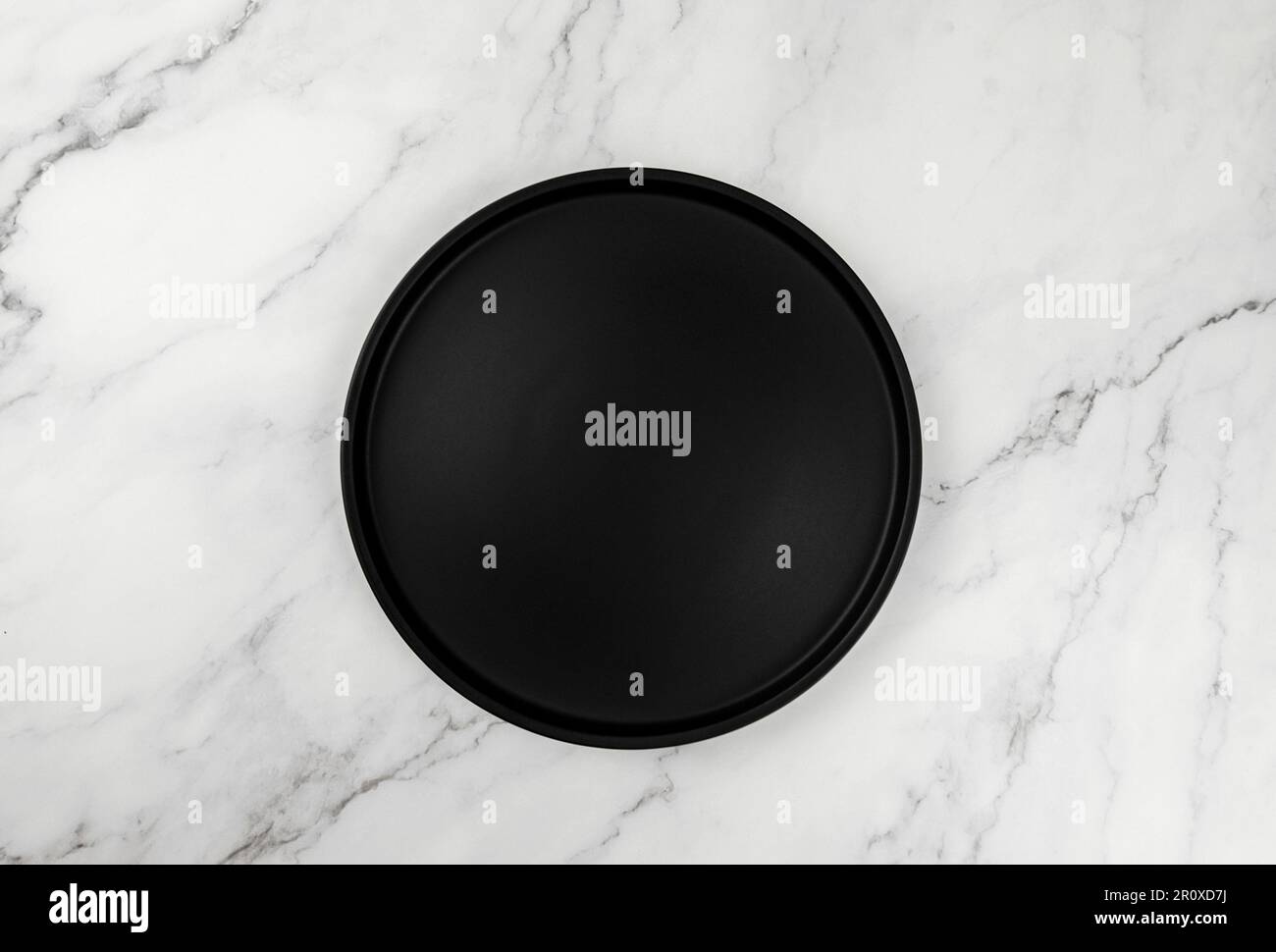 Draufsicht auf schwarzes Schild auf weißem Marmorhintergrund. Lebensmittelpräsentation flach liegend. Speicherplatz kopieren. Stockfoto