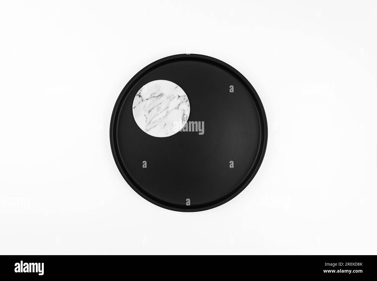 Draufsicht der schwarzen Platte auf weißem Hintergrund. Marmorablage flach liegend, Kopierraum. Stockfoto