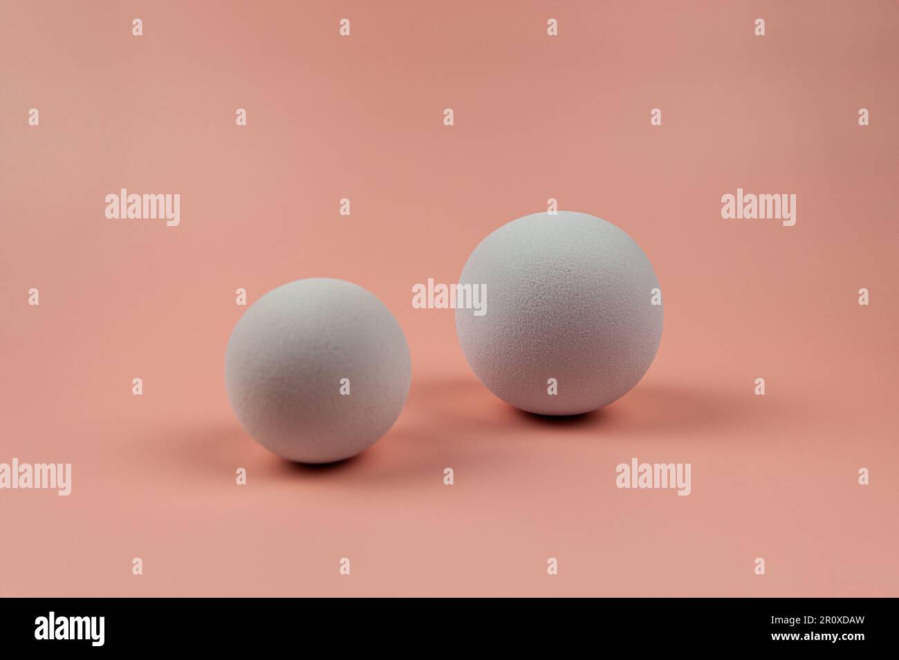 3D weiße Bälle auf pinkfarbenem Hintergrund. Zwei Kugeln Komposition. Speicherplatz kopieren. Stockfoto