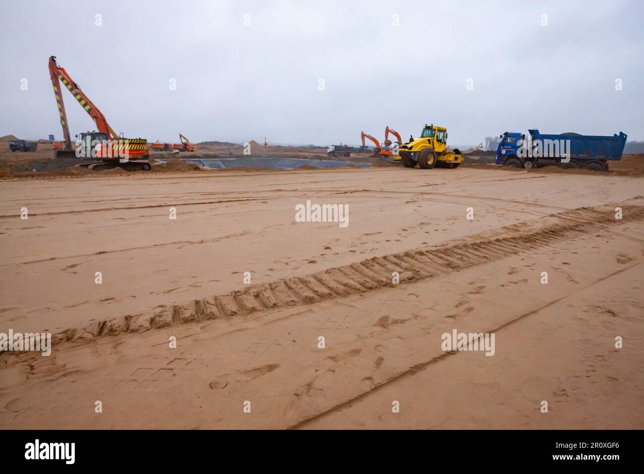 Bodenträger und LKW-Reifenprofil anschleifen. Straßenbaustelle. Unscharfer Hintergrund Stockfoto