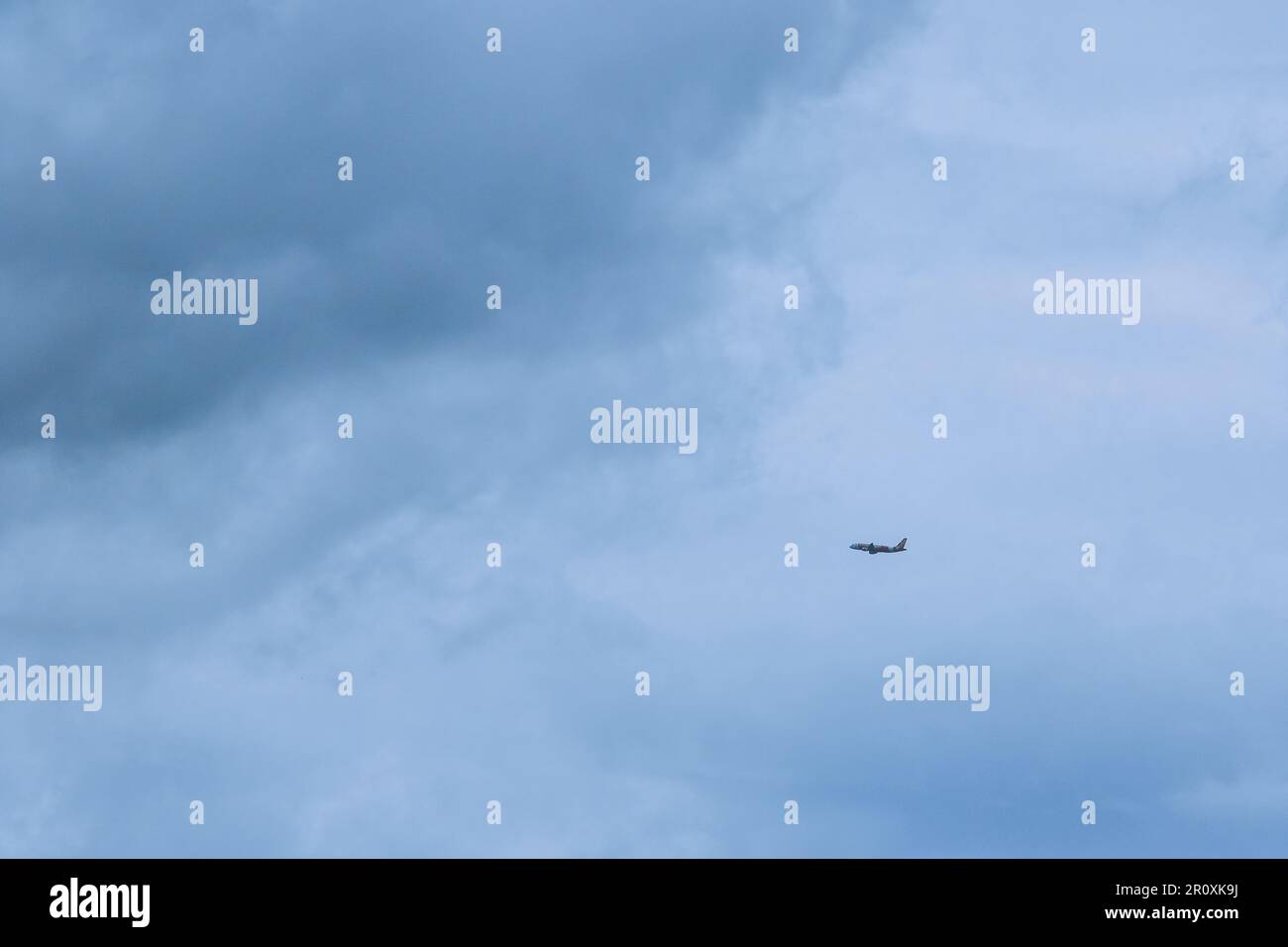 Ein kleines Passagierflugzeug flog durch eine große Regenwolke. Stockfoto