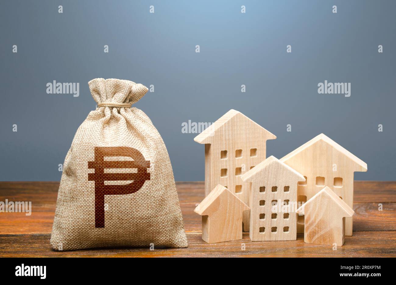 Häuser und philippinischer Peso-Geldbeutel. Gemeindehaushalt. Investitionen in Immobilien und Bauwirtschaft. Energieeffizienz und Kosten für Stockfoto