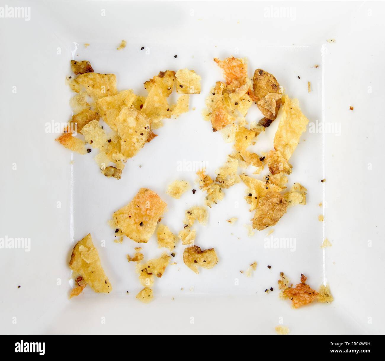 Die letzten Chips. Knusprige Krümel in weißer Schale Stockfoto