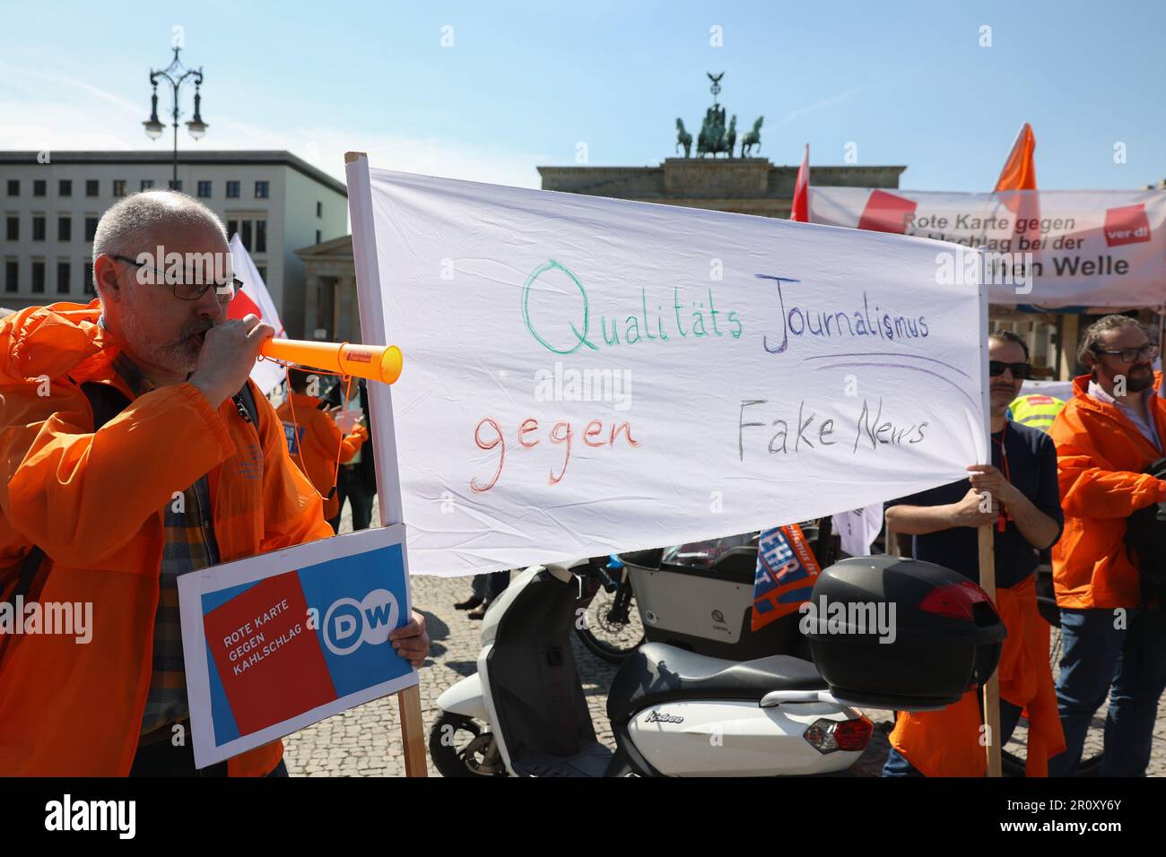 Berlin, Deutschland. 10. Mai 2023. „Quality Journalism Against Fake News“ steht auf einem Banner bei einer Demonstration von Mitarbeitern der Deutschen Welle auf dem Pariser Platz. Sie demonstrieren gegen die Kostensenkungspläne ihres Arbeitgebers. Die Pläne sehen 100 Vollzeitstellen an den inländischen Standorten in Berlin und Bonn vor. Kredit: Jörg Carstensen/dpa/Alamy Live News Stockfoto