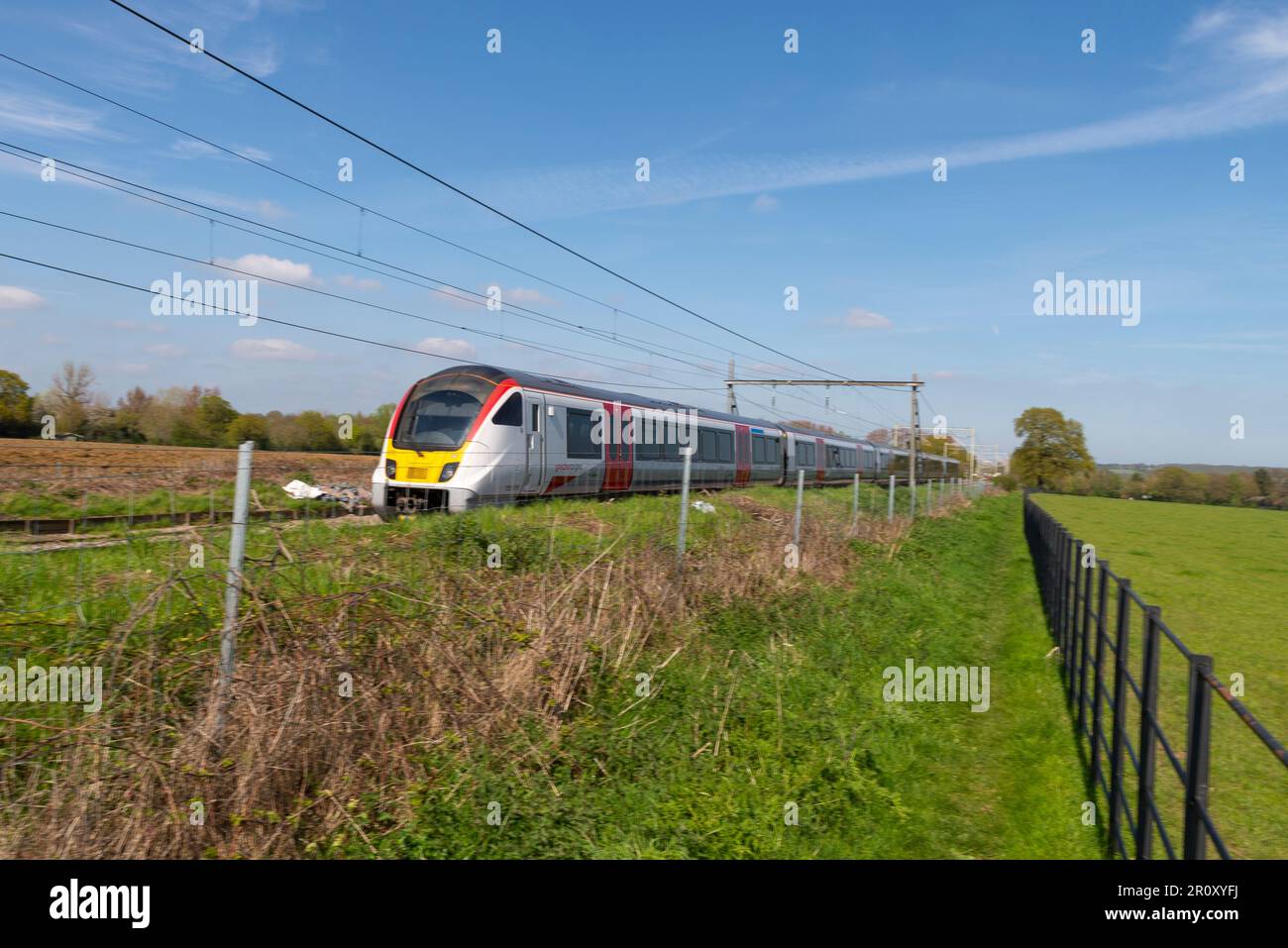 British Rail Klasse 720 Aventra von Greater Anglia, mit Geschwindigkeit durch die Landschaft in der Nähe von Margaretting in Richtung London Liverpool Street, Großbritannien Stockfoto