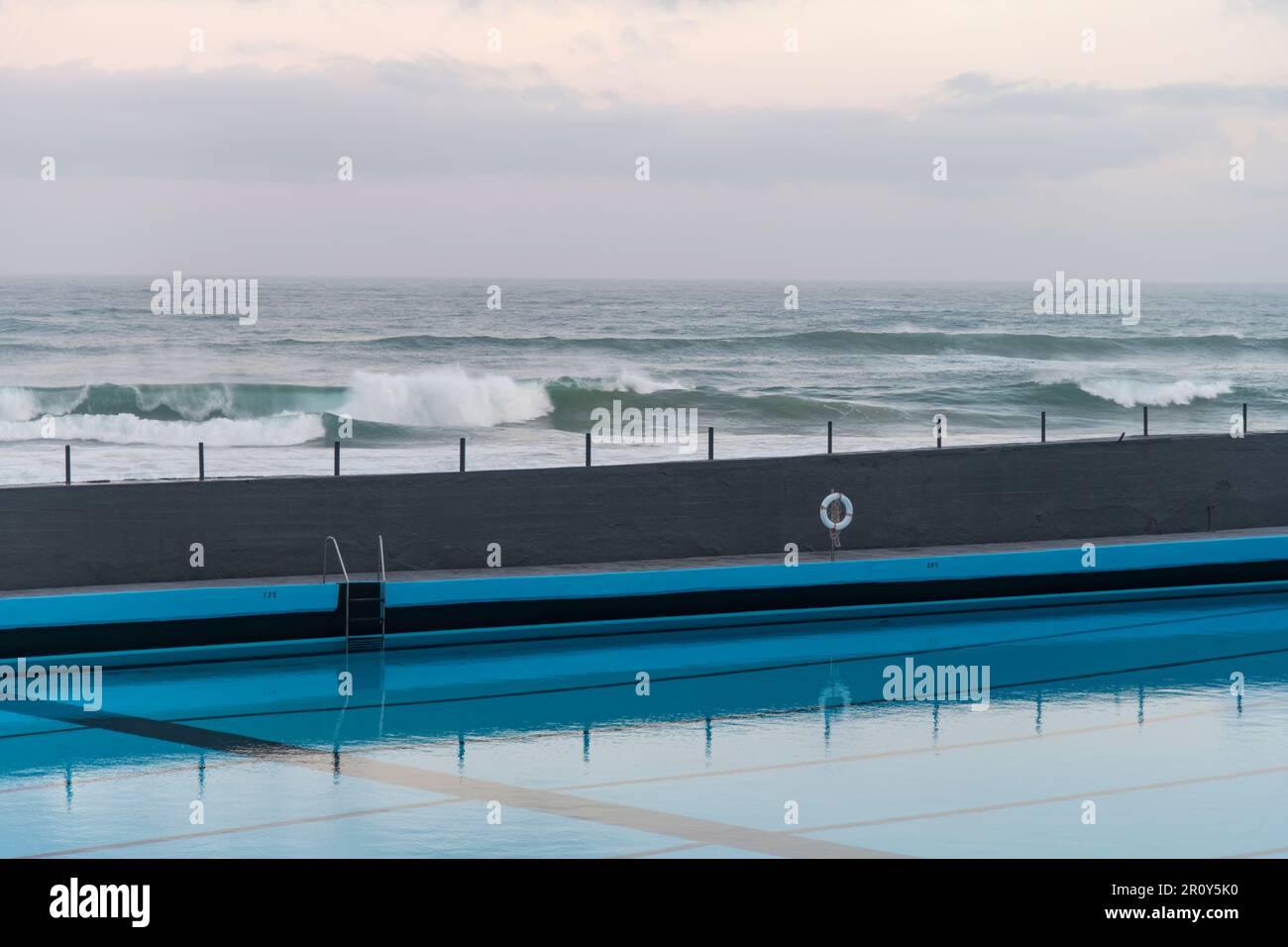 Blick von oben entlang der Küste eines großen Salzwasserpools mit ruhiger und glatter Wasseroberfläche und Reflexion im Wasser Stockfoto