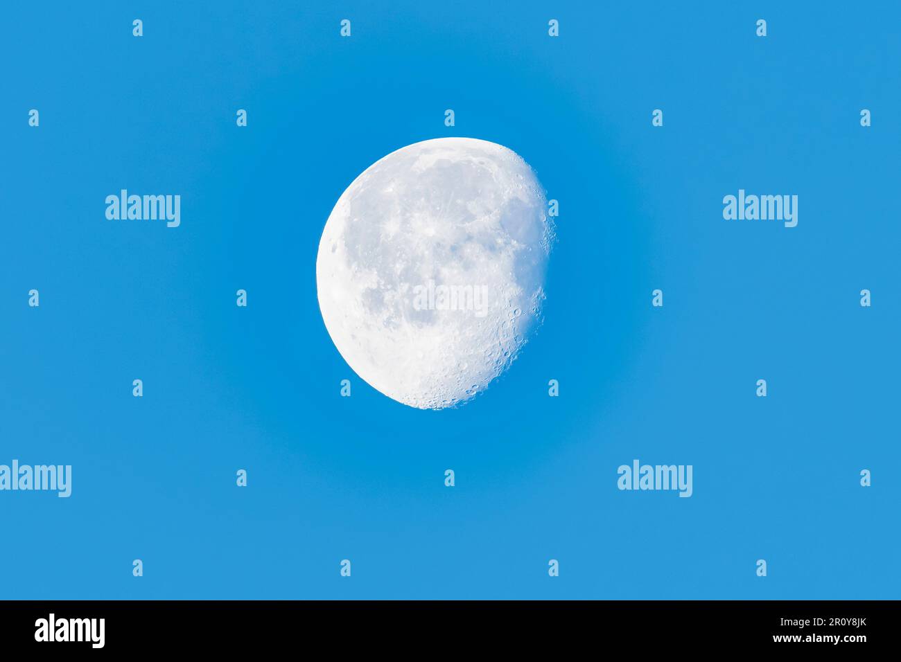 Hell erleuchteter, schwindender Mond am blauen Himmel Stockfoto