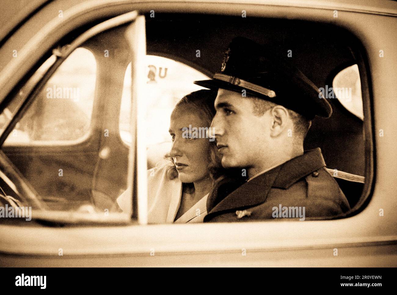 Ein junger Offizier und seine Frau in ihrem Auto auf der Anklagebank sitzen anstarren ruhig seine Flugzeugträger warten bevor er für Korea verlässt.  1950 Stockfoto