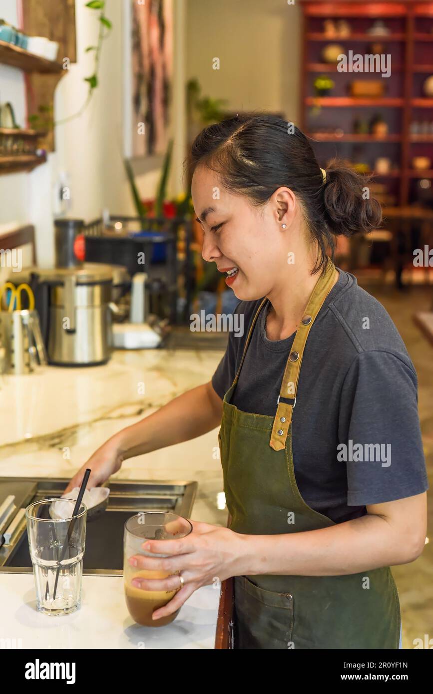 Der vietnamesische Barista fügte Eis und Stroh im vietnamesischen Café Sua hinzu Stockfoto