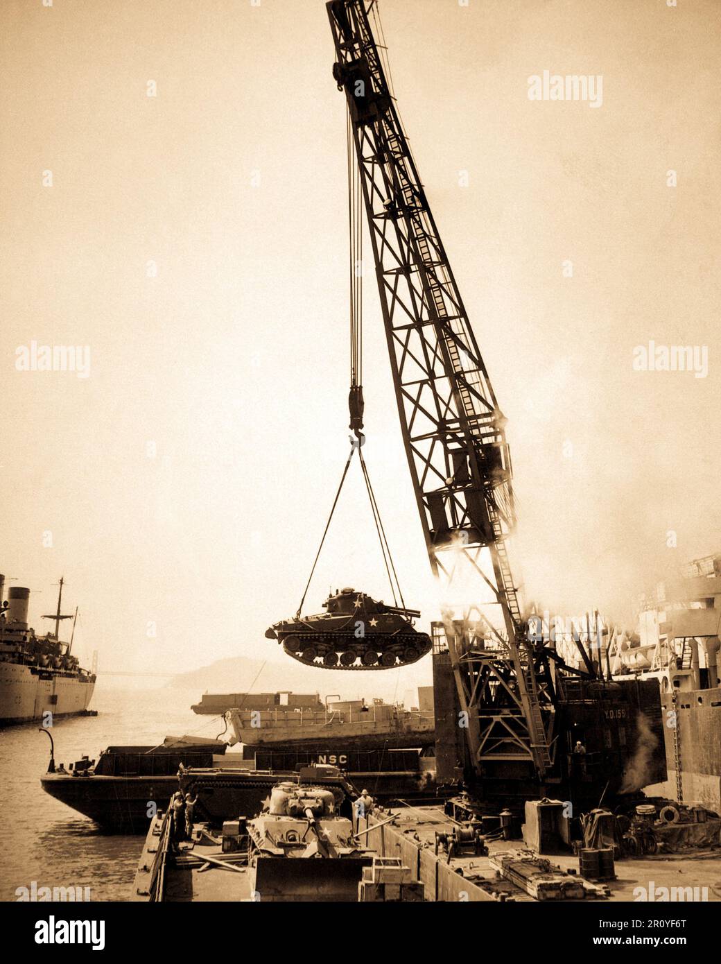 Marinekorps-Panzer - bereit für die Front - werden an Bord einer Barke an der Naval-Versorgungsmaterial-Mitte mit einem Kran für Umladen auf unserer Streitkräfte im Pazifik Far Eastern Befehl geschwungen.  Oakland, CA, 1950. Stockfoto