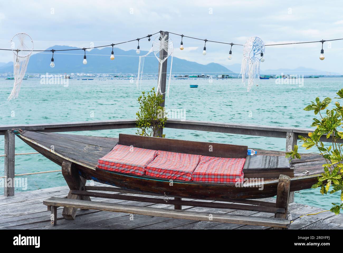 Holzbank mit Kissen auf einem hölzernen Pier im südchinesischen Meer in vietnam Stockfoto