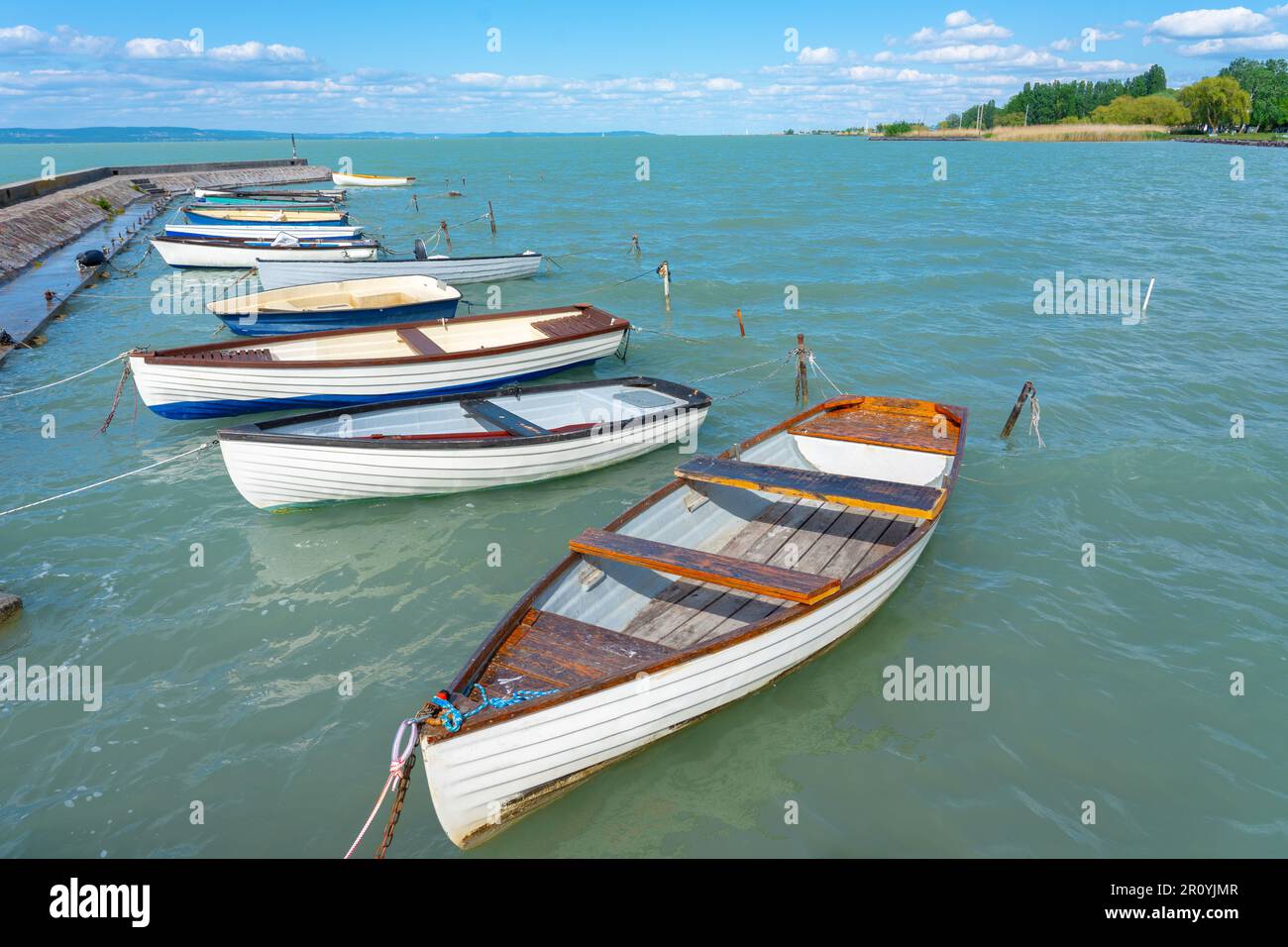 pier in Balatonlelle mit farbenfrohen Booten auf dem blauen Himmel und Wasser des Balaton Stockfoto