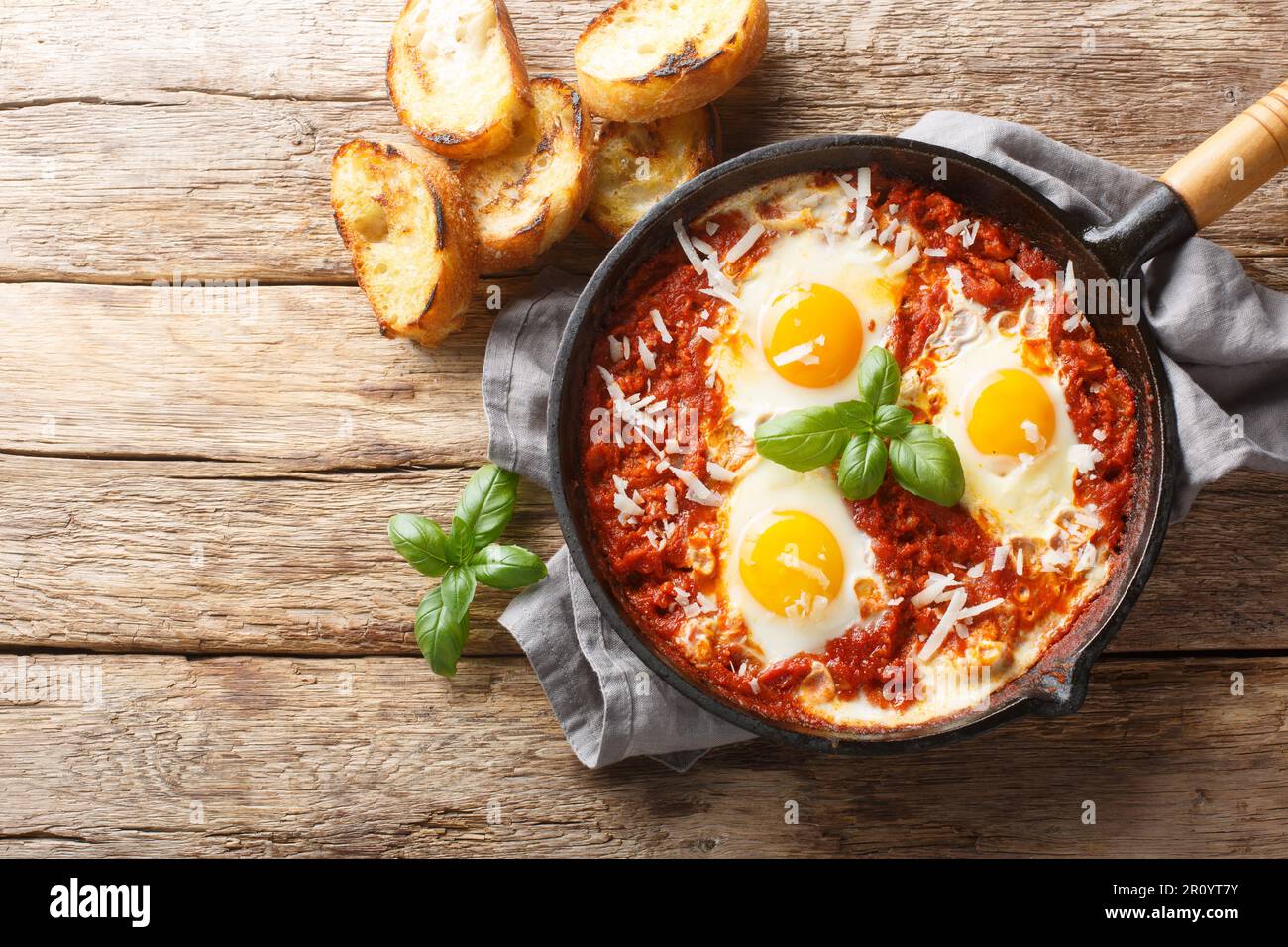 Eggs in Purgatory ist ein köstliches süditalienisches Gericht, bestehend aus Spiegeleiern in einer scharfen Tomatensoße mit Zwiebeln und Knoblauch auf der Pfanne Stockfoto