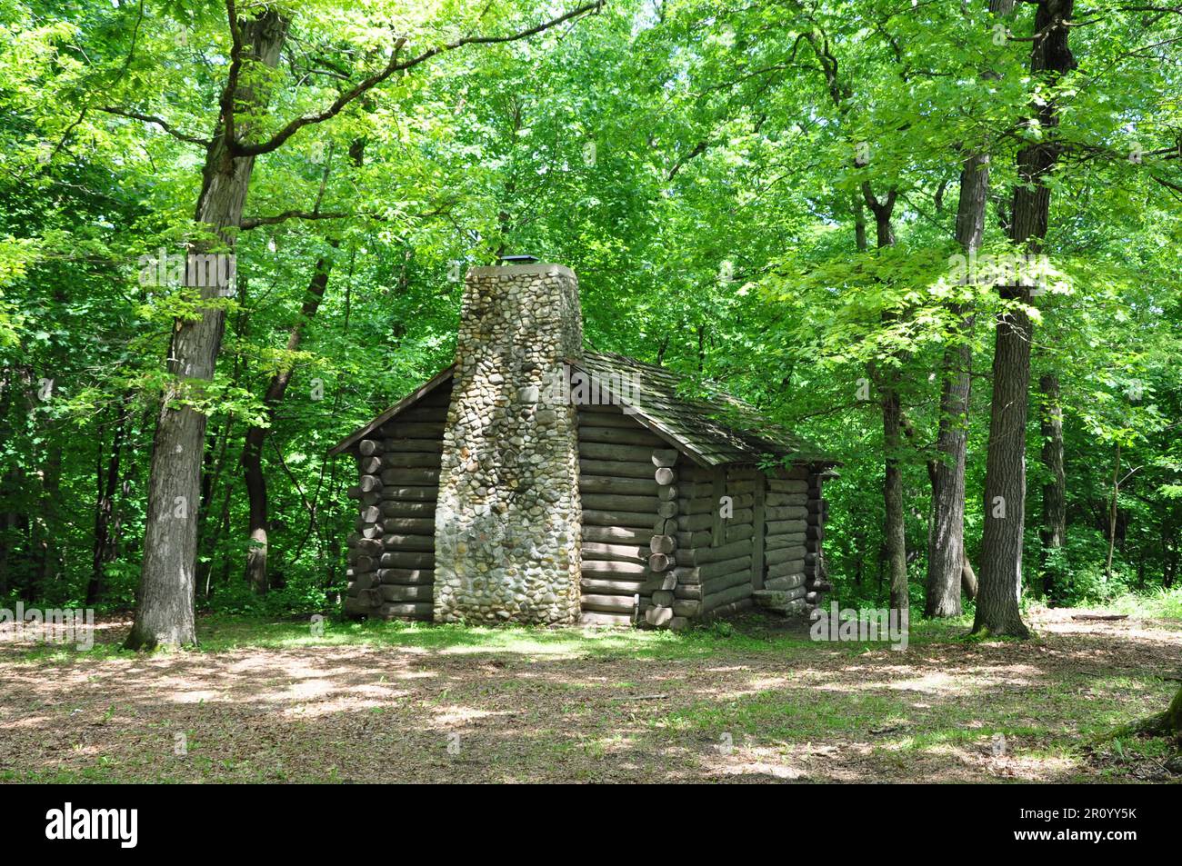 Eine alte Blockhütte, eingebettet in die Bäume Stockfoto