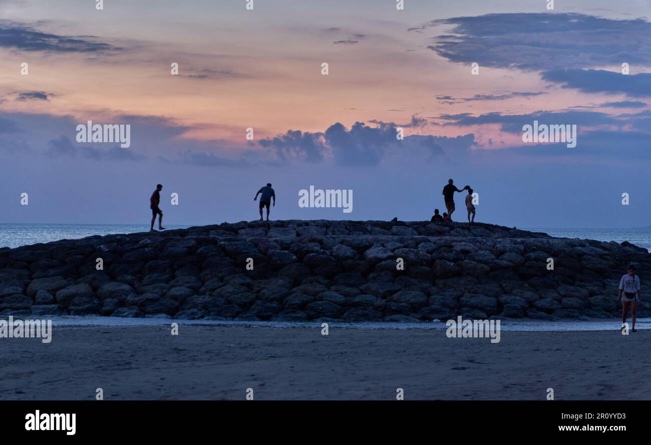 Pantai Jerman (deutscher Strand) in Kuta, Bali Indonesien bei Sonnenuntergang, bei dem die Leute den Strand genießen Stockfoto