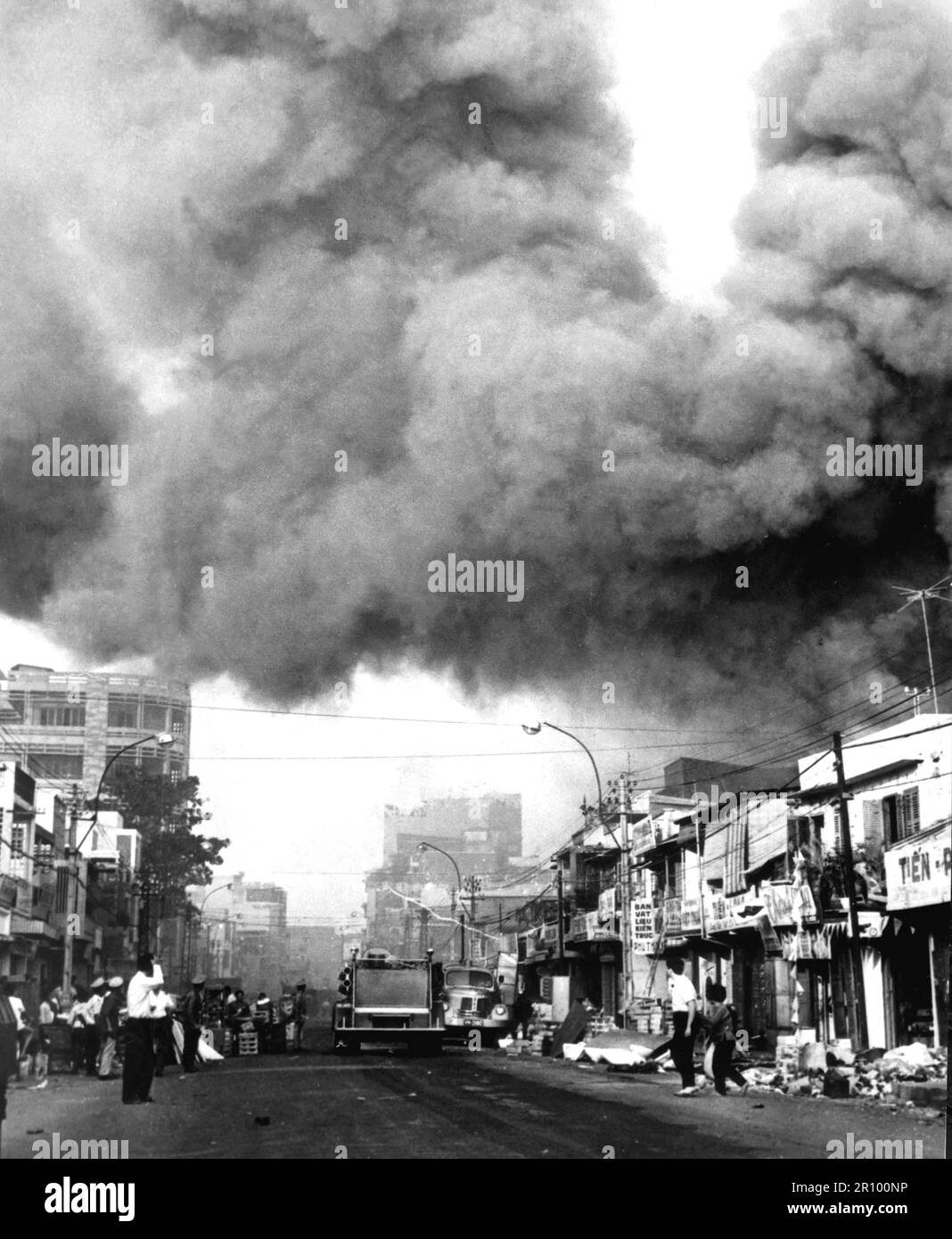 Schwarzer Rauch bedeckt Bereiche von Saigon, während Feuerwehrautos zu den Schauplätzen von Bränden eilen, die während der Tet-Feiertage von den Vietcong angegriffen wurden. Ungefähr 1968. Stockfoto