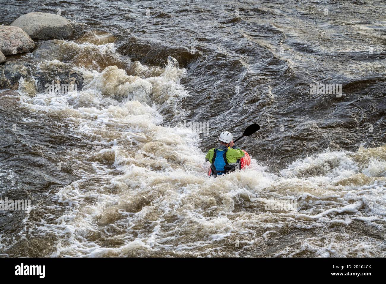 Im Whitewater Park am Poudre River im Zentrum von Fort Collins, Colorado, könnt ihr mit dem Kajak auf der Welle surfen Stockfoto