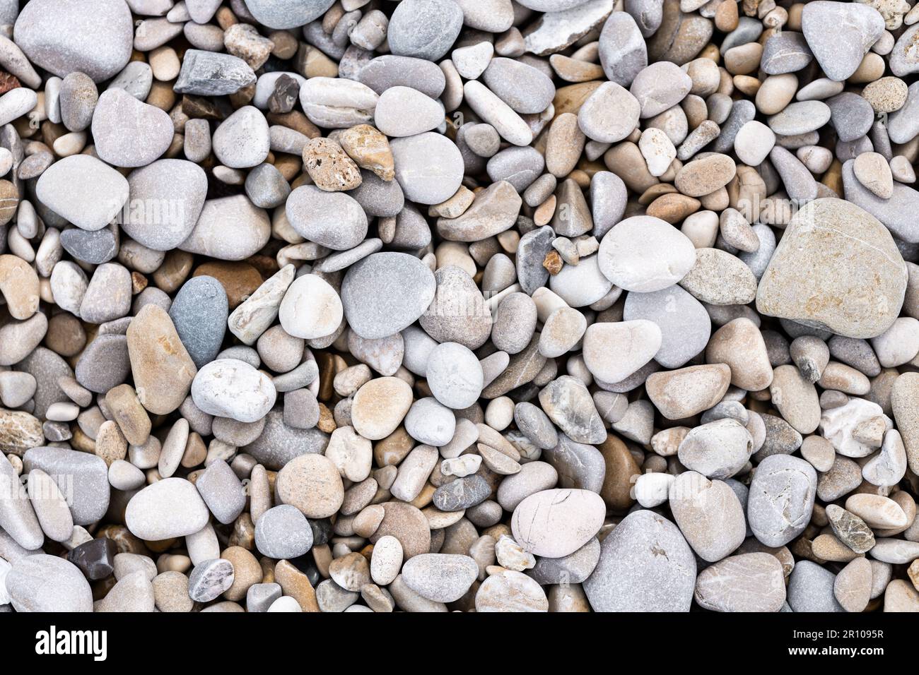 Runde Kieselsteine am Strand. Grauer Steinhintergrund, Seeküste Stockfoto