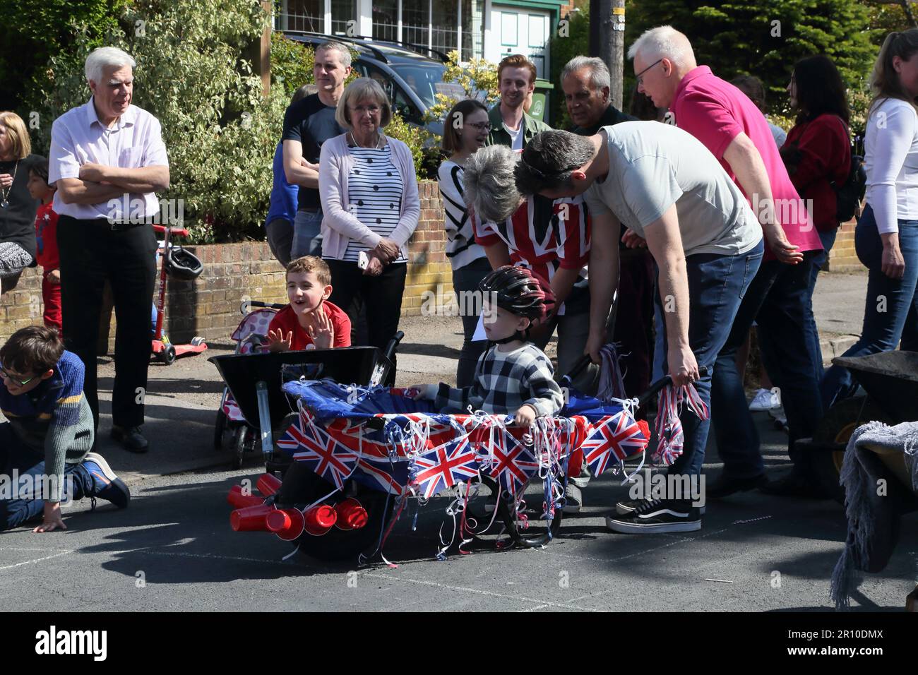 Familien, die am Wheelbarrow Race bei der Street Party teilnehmen, um König Charles III. Krönung Surrey England zu feiern Stockfoto