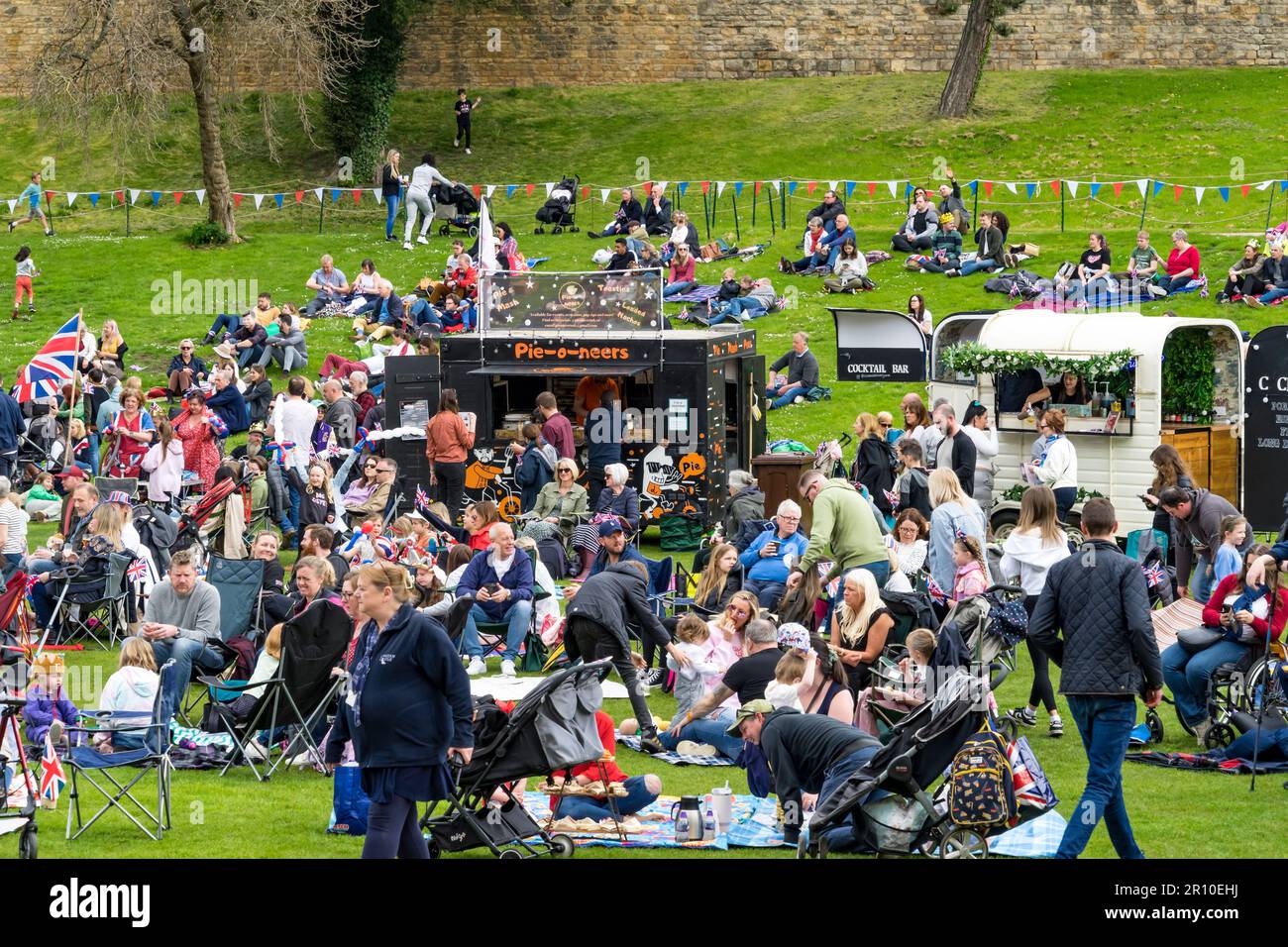 Viele Menschen versammelten sich in der Nähe von Restaurants und Bars auf dem Gelände des Schlosses, um König Karl III. Krönung auf einem Großbildfernseher am 6. Mai 2023 in Lincoln City zu sehen Stockfoto