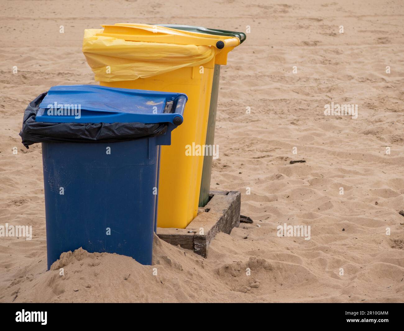 Saubere und nachhaltige Strände: Bedeutung bunter Recyclingbehälter Stockfoto