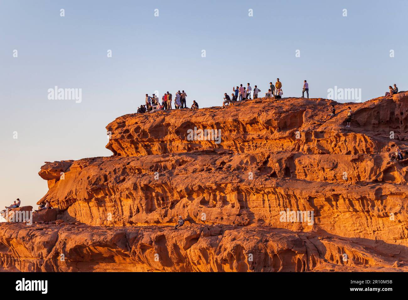 Leute, die den Sonnenuntergang von einer Sandsteinklippe aus beobachten, Wadi Rum, Jordan Stockfoto