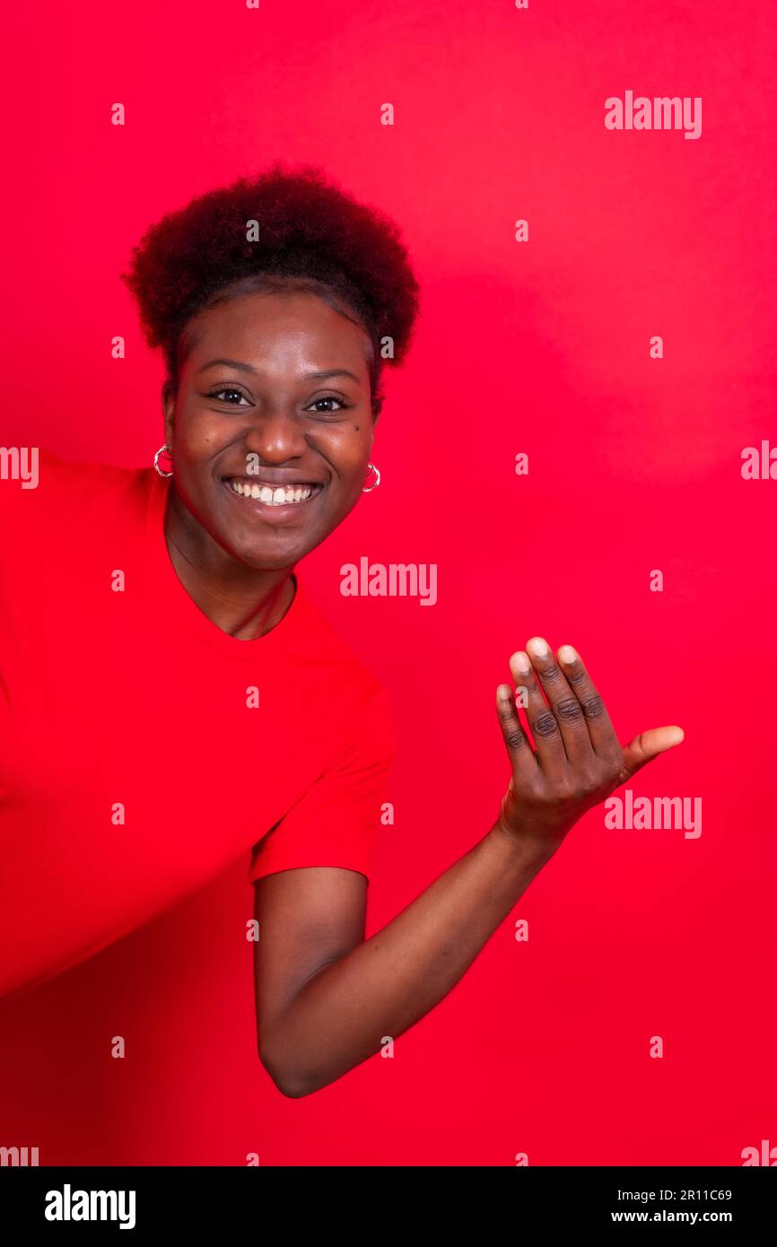 Junge afroamerikanische Frau isoliert auf rotem Hintergrund, die mit der Hand kommen möchte Stockfoto