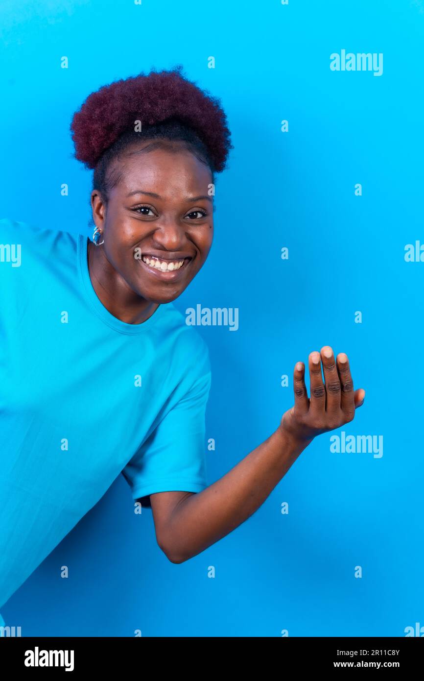Junge afroamerikanerin isoliert auf blauem Hintergrund, die mit der Hand kommen will Stockfoto
