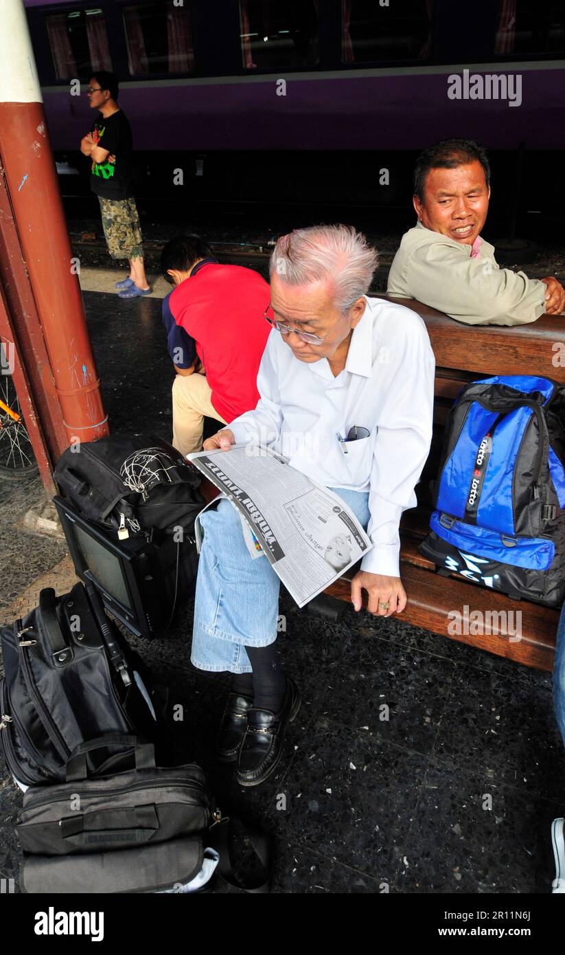 Thailändische Männer warten auf den Zug am Bahnhof Hua Lamphong in Bangkok, Thailand. Stockfoto