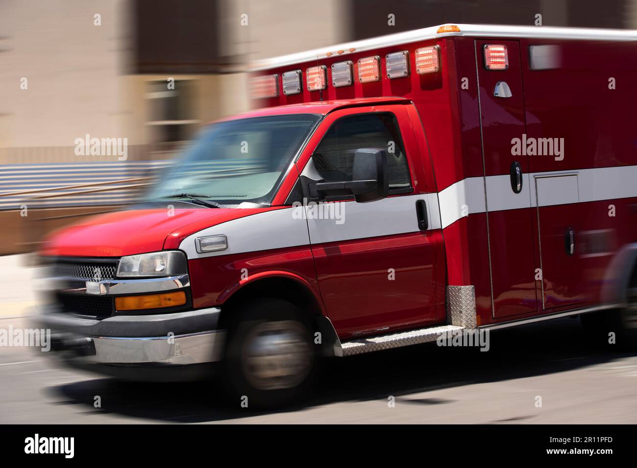 Tagsüber bewegte unscharfe Sicht eines Krankenwagens, der zum Unfallort rast. Stockfoto
