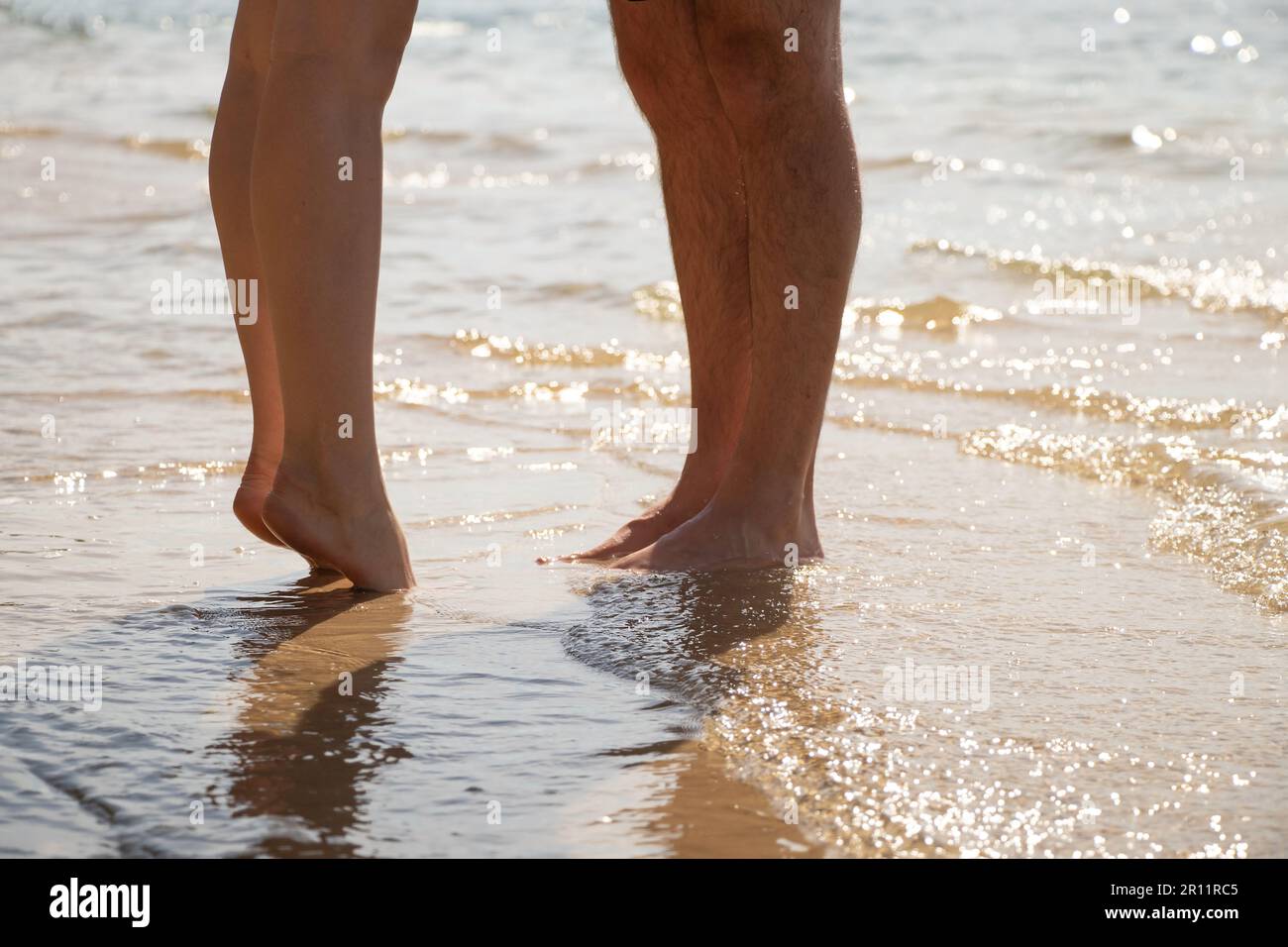Männliche und weibliche Füße im Meerwasser Bodenansicht in der Sonne Stockfoto