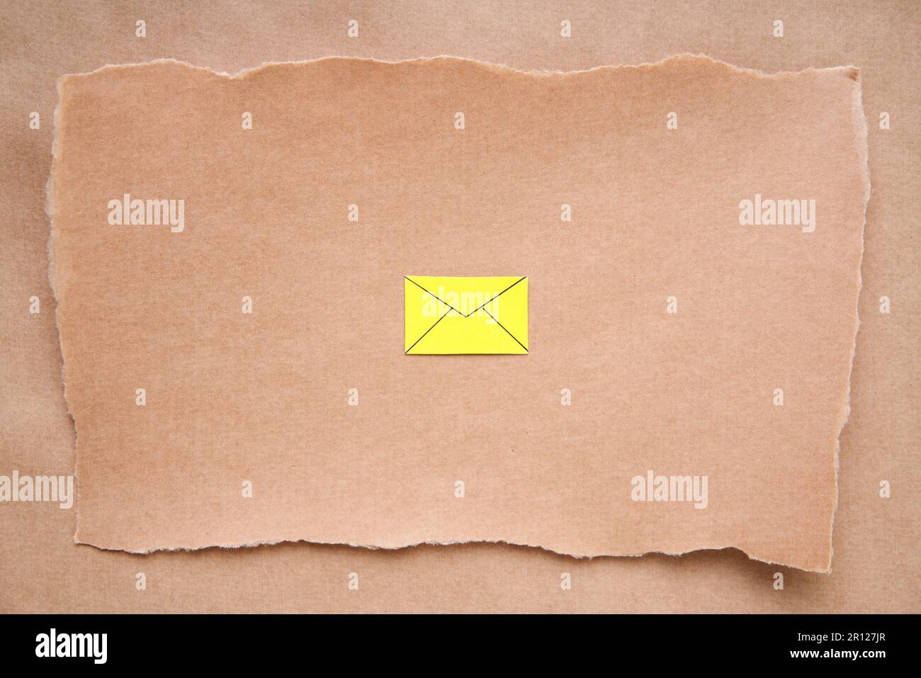 Gestalten Sie eine Postkarte mit gelbem E-Mail-Symbol und Papierkunst. Grußkarte, Brief, Einladungsmodell auf Grunge-Papier-Hintergrund. Flach liegend, Draufsicht, Bulle Stockfoto
