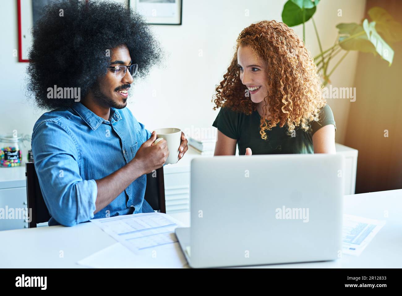 Das könnte unser bisher bahnbrechendstes Design sein. Zwei junge Designer, die gemeinsam in einem Büro ein Brainstorming durchführen. Stockfoto