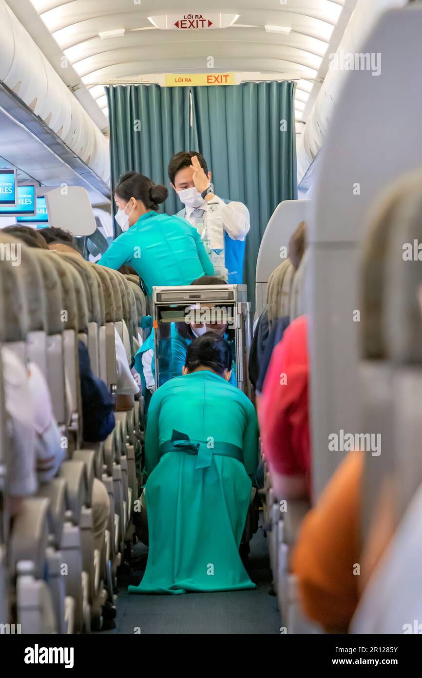Vietnam Airlines Kabinenbesatzung trägt traditionelle AO dai Uniform auf dem Flug Stockfoto