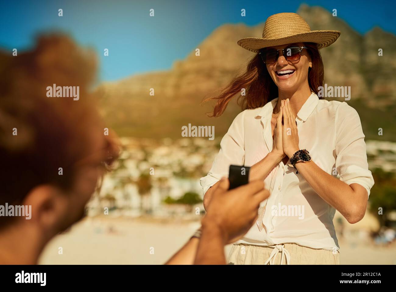 Im Sommer hat sie ja gesagt. Eine junge Frau, die sich an einem Sommertag am Strand verlobt. Stockfoto