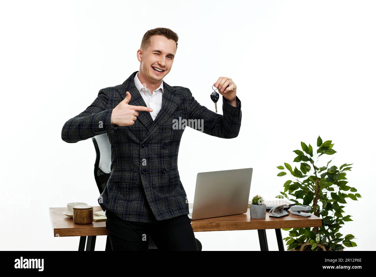 Erfolgreicher weißer, fröhlicher Mann mit einem Schlüssel Stockfoto