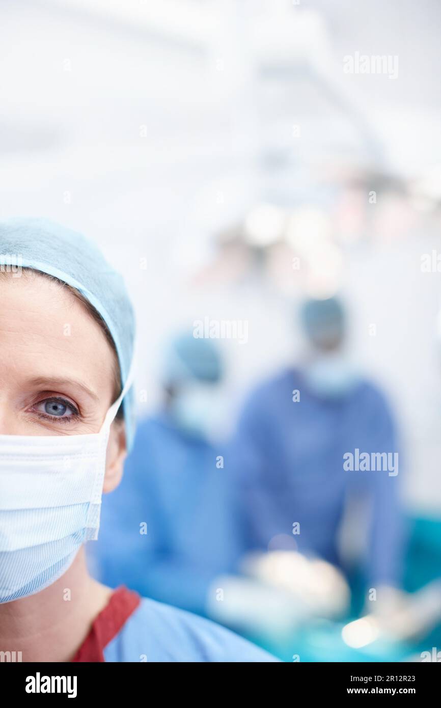 Ich tue alles, was möglich ist. Gekürzte Nahaufnahme einer reifen Chirurgin trägt Krankenhauspeeling und eine schützende Gesichtsmaske - Copyspace. Stockfoto