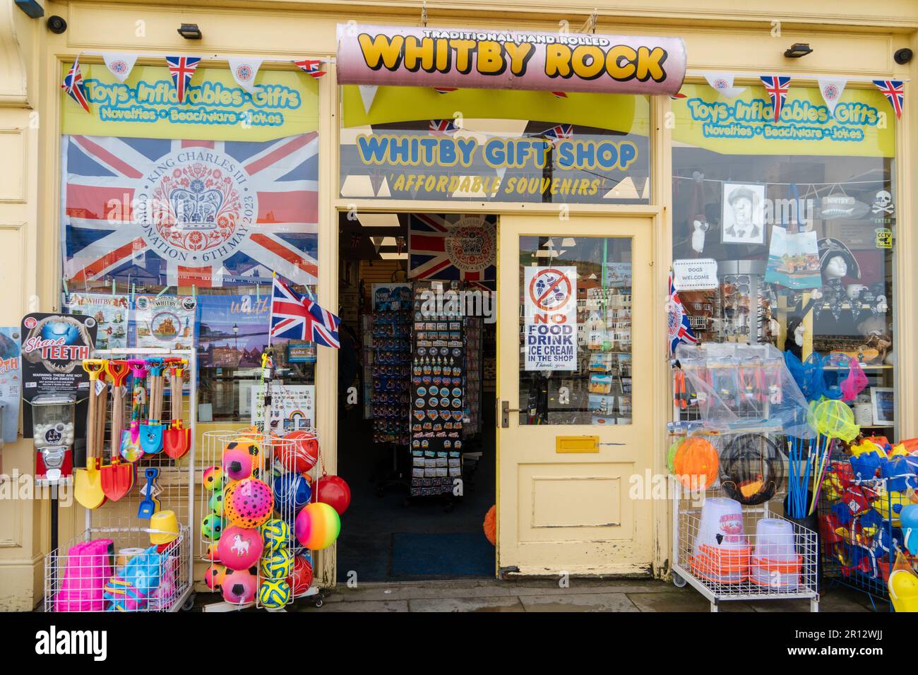 Der Souvenirladen „Whitby Rock“ am Hafen in der Stadt Whitby, North Yorkshire, Großbritannien, verkauft Eimer und Pik. Stockfoto