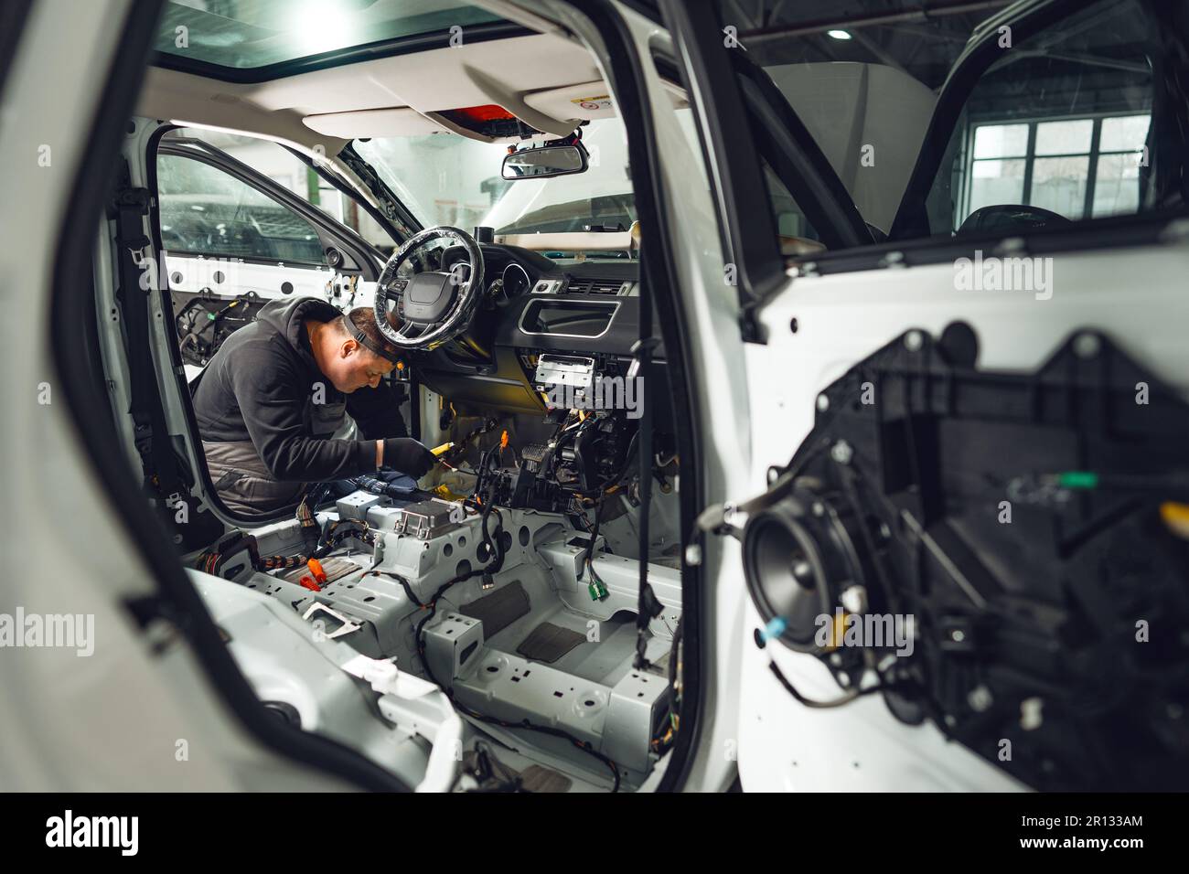 Tuning-service-mitarbeiter installieren schallschutzmaterial im innenraum  des autos