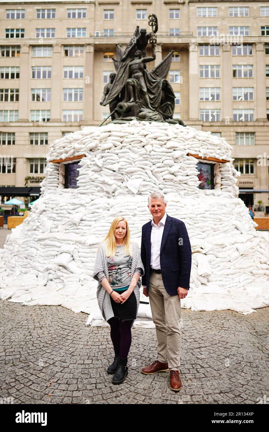 Eurovision-Minister Stuart Andrew (rechts) mit Esther Simpson aus „Whispered Tales“ neben „Protect the Beats“ während seiner Tour durch das EuroFestival Village in Liverpool. Die Kunstinstallation bestehend aus über 2.500 Sandsäcken wurde von geflüsterten Geschichten in Kollaation mit dem ukrainischen Musiker Denys Kashchei geschaffen. Foto: Donnerstag, 11. Mai 2023. Stockfoto