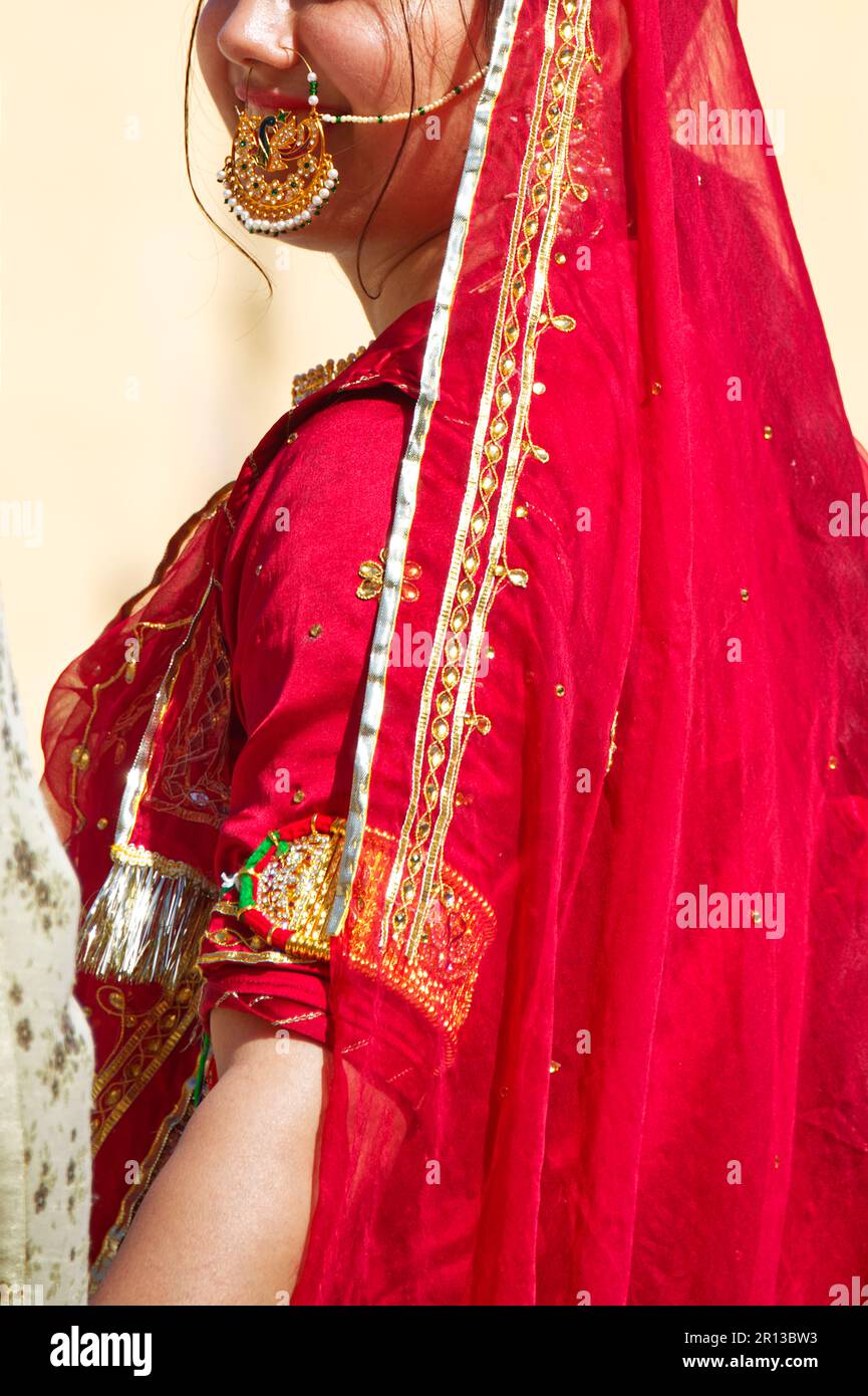 Teilansicht einer Braut in rotem Hochzeitskleid und traditionellem indischem Schmuck Stockfoto